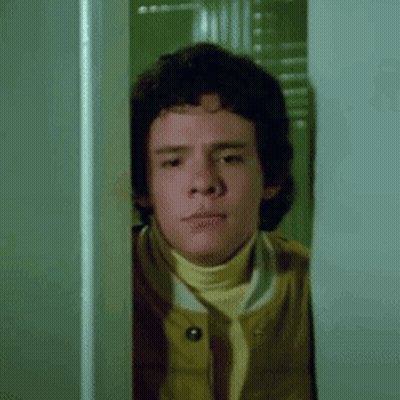 Young Man Peeking Out Of Doorway GIF
