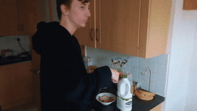 Young Man Pouring Milk Into Bowl GIF