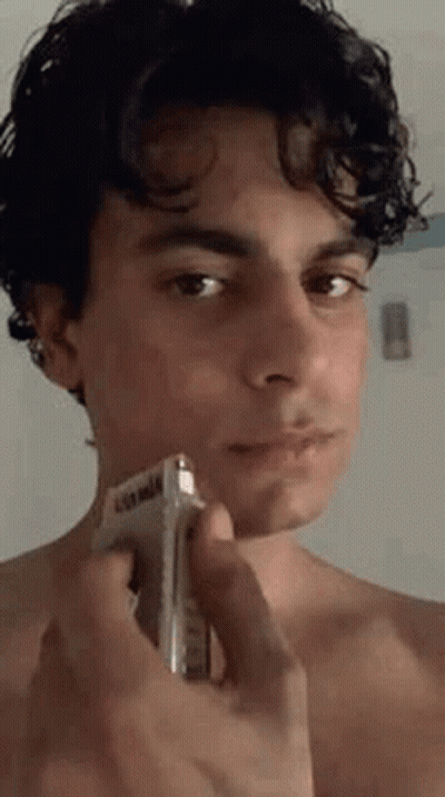 Young Man Shirtless Shaving Face With Razor GIF