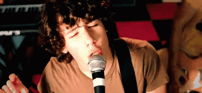 Young Man Singing Into Microphone Playing Guitar GIF