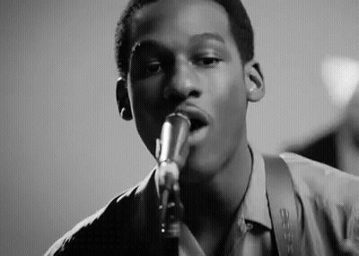 Young Man Singing Into Microphone Playing Saxophone GIF