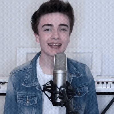 Young Man Singing Into Microphone With Keyboard GIF