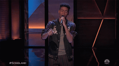Young Man Singing On Stage With NBC Logo GIF
