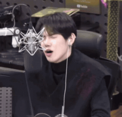 Young Man Sitting At Microphone Eyes Closed GIF