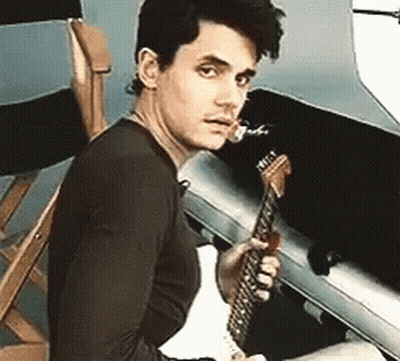 Young Man Sitting In Chair Holding Guitar GIF