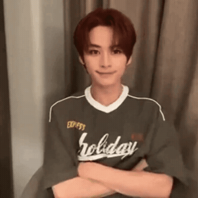 Young Man Sitting In Chair With Arms Crossed Green Shirt GIF