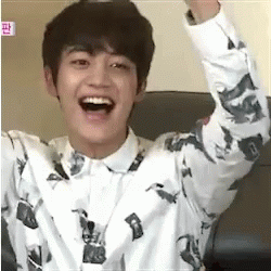 Young Man Sitting Laughing With Arms Up GIF