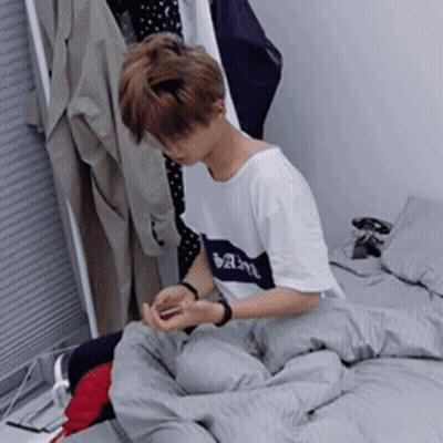 Young Man Sitting On Bed Looking At Phone GIF