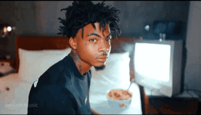 Young Man Sitting On Bed With Bowl Of Cereal GIF