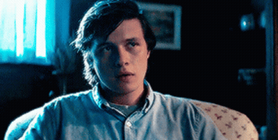 Young Man Sitting On Couch In Dark Room GIF