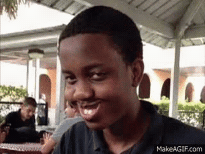Young Man Smiling And Making Funny Face At Table GIF
