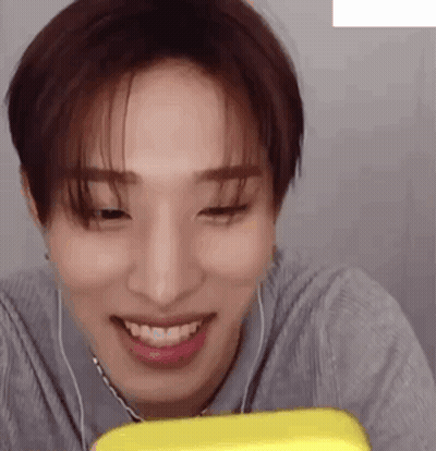 Young Man Smiling At Yellow Item With Headphones GIF