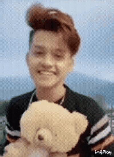 Young Man Smiling Holding Teddy Bear GIF