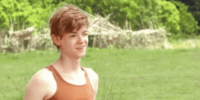 Young Man Smiling In Field In Tank Top GIF