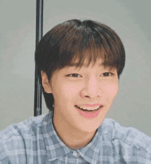 Young Man Smiling In Plaid Shirt GIF