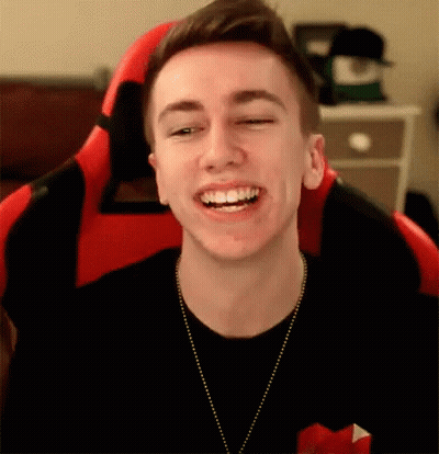Young Man Smiling In Red And Black Chair GIF