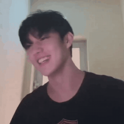 Young Man Smiling Making Funny Face In Black T-Shirt GIF