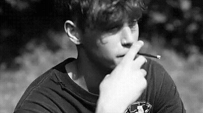 Young Man Smoking Cigarette In Park GIF