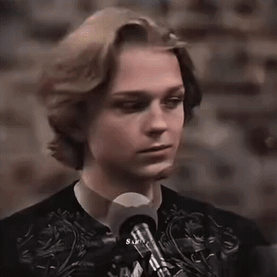 Young Man Standing At Microphone In Dark Room GIF
