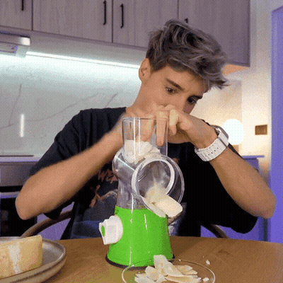 Young Man Using Green And White Blender To Slice Vegetables GIF