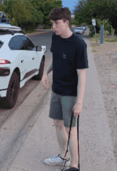 Young Man Walking Dog In Front Of White SUV GIF