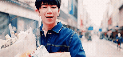 Young Man Walking With Bouquet Smiling GIF