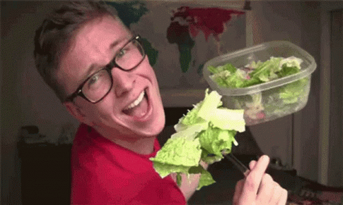Young Man Wearing Glasses Holding Plastic Container Of Lettuce GIF