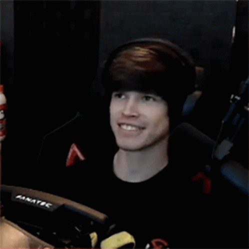 Young Man Wearing Headphones Smiling In Front Of Fanatec Monitor GIF