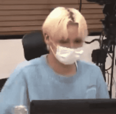 Young Man Wearing Mask Sitting At Computer GIF