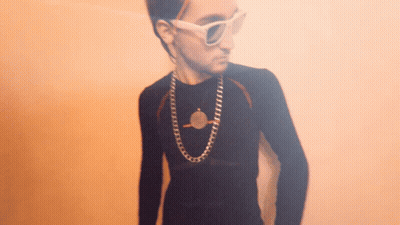 Young Man Wearing Sunglasses and Coin Necklace