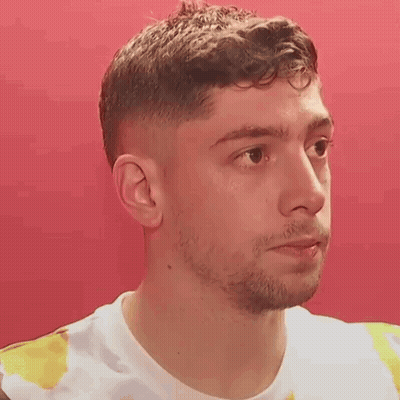 Young Man With Beard In Tie Dye Shirt Looking At Camera GIF