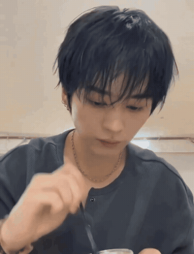 Young Man With Black Hair And Necklace Eating With Spoon GIF