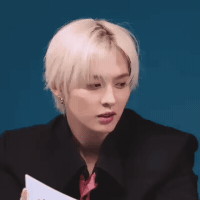 Young Man With Blonde Hair Holding Paper GIF