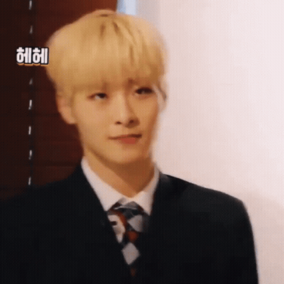 Young Man With Blonde Hair In Suit And Tie Looking At Camera GIF