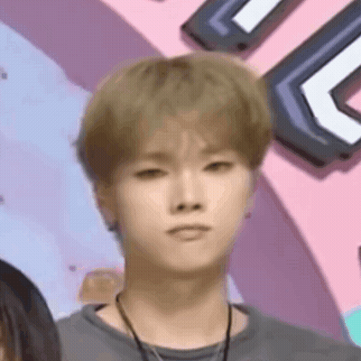 Young Man With Blonde Hair Making Funny Face In Front Of Pink Wall GIF