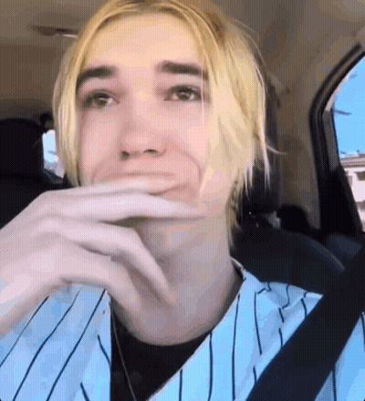 Young Man With Blonde Hair Sitting In Back Seat Hand On Mouth GIF