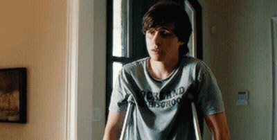 Young Man With Crutches In Rock And Roll School Shirt GIF