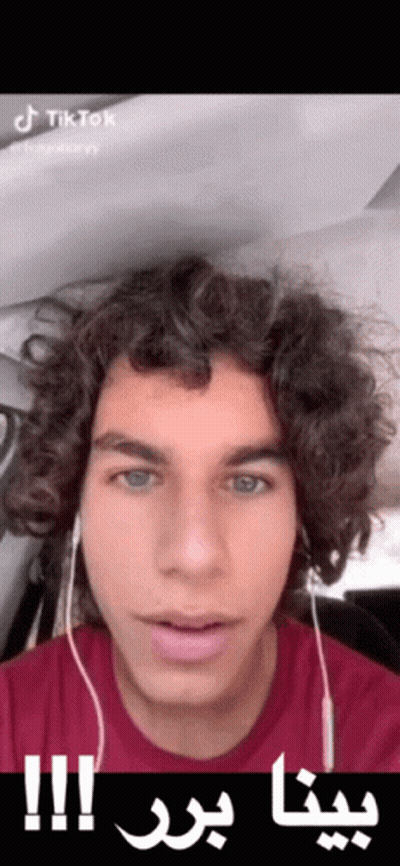 Young Man With Curly Hair Headphones Red Shirt Arabic Writing On Face GIF