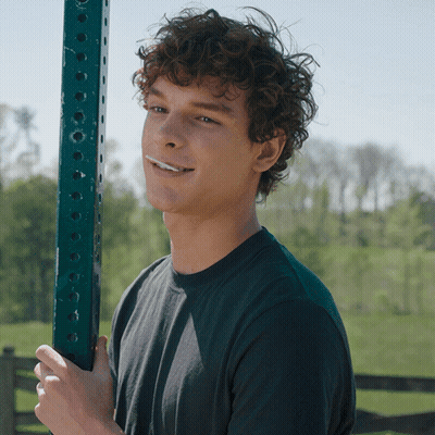 Young Man With Curly Hair Holding Green Pole GIF