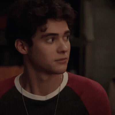Young Man With Curly Hair In Black And Red Sweater GIF
