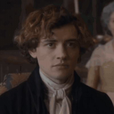 Young Man With Curly Hair In Black Jacket And White Tie GIF