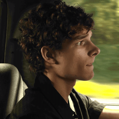 Young Man With Curly Hair In Driver's Seat GIF