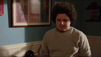Young Man With Curly Hair In Grey Sweatshirt GIF