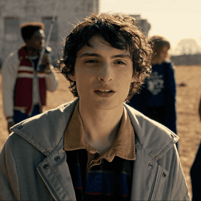 Young Man With Curly Hair In Jacket And Plaid Shirt GIF