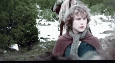 Young Man With Curly Hair In Red Cape And Scarf Standing In Snow GIF