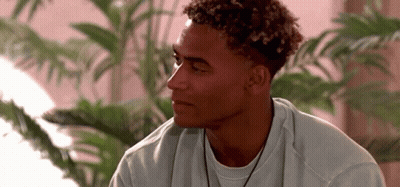 Young Man With Curly Hair In White Sweater And Necklace GIF