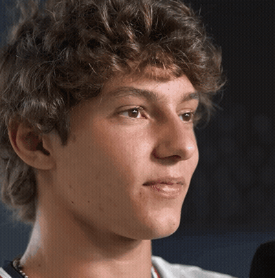 Young Man With Curly Hair Looking At Camera GIF