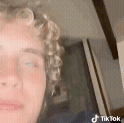 Young Man With Curly Hair Looking At Camera GIF