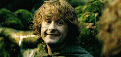 Young Man With Curly Hair Smiling In Front Of Waterfall GIF