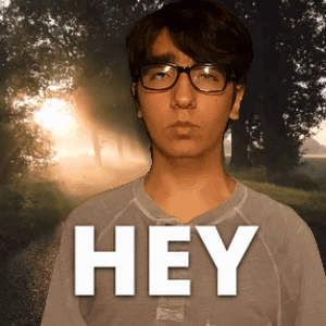 Young Man With Glasses And Grey Shirt Saying Hey GIF